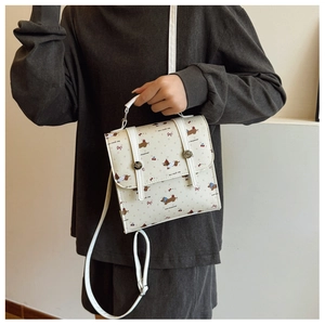 Détail du mini sac blanc à motif de chiens de dessin animé et imprimés cerises