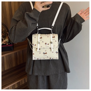 Détail du mini sac à dos crème avec motif teckel et boucles argentées réglables