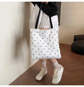 Close-up of floral canvas tote bag featuring white lace trim and black flower patterns