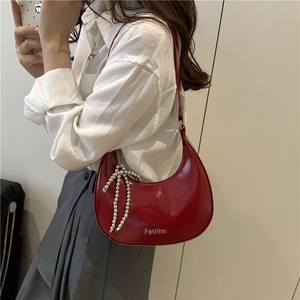 Red glossy patent leather half-moon shoulder bag with a stylish silver bow charm