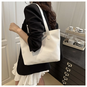 Detail of cream-white corduroy tote bag showing textured fabric and large capacity size
