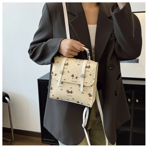 Detail of cute dachshund print and leather piping on a stylish cream mini shoulder bag