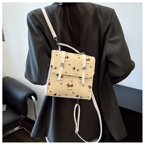 Détail du sac crème avec imprimés teckel et cerise et fermoir en métal argenté brillant