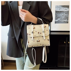 Détail d'un mini sac à dos beige avec imprimé teckel et boucle métallique décorative