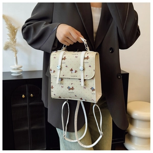 Détail d'un sac à dos crème en cuir PU avec motifs de teckels et cerises pour femme