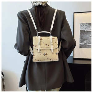 Rear view of model wearing a mini square backpack with cartoon dachshund and cherry prints