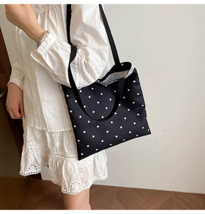 Detail of floral canvas tote bag featuring white lace trim and black ribbon shoulder strap