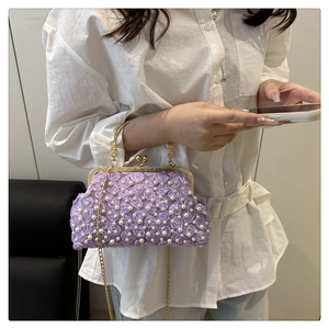 Dettaglio dei fiori in pizzo viola e delle perle su questa elegante borsa da sera