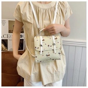 Détail du sac carré jaune avec motifs teckel et cerises sur un cuir PU souple et chic