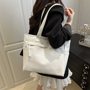 Minimalist white woven tote bag with side pockets and wide shoulder strap for women