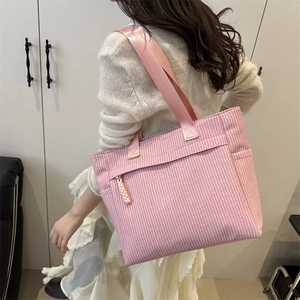 Pink striped textured tote bag with front zipper pocket and wide shoulder strap