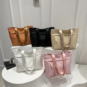 Large corduroy tote bags in five colors with front zipper pockets and side slots