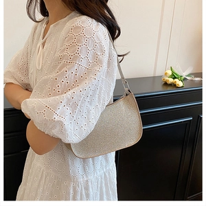 Détail d'un sac hobo doré avec texture scintillante et fermeture éclair métallique chic