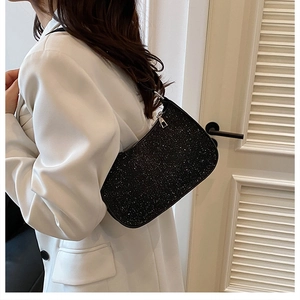Detail of black sequined baguette shoulder bag showing glitter texture and silver zipper