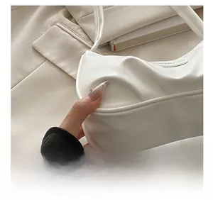 Detail shot of white pleated crescent bag with fine stitching and fashion hardware