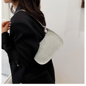 Close-up of sparkling silver sequin underarm bag worn with a chic black suit jacket