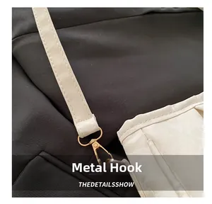 Macro detail of golden metal swivel hook on white leather strap for shoulder bag