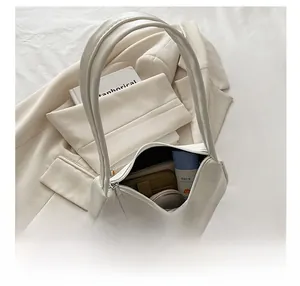Detailed interior of a white underarm bag showing wallet and cosmetic storage