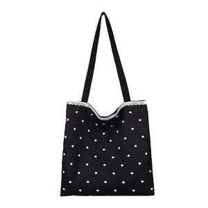 Black floral canvas tote bag with white lace trim and minimalist ribbon handles