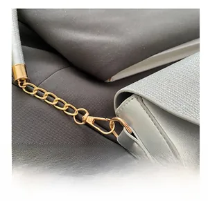Close-up of golden metal lobster clasp and silver sequin leather strap on handbag