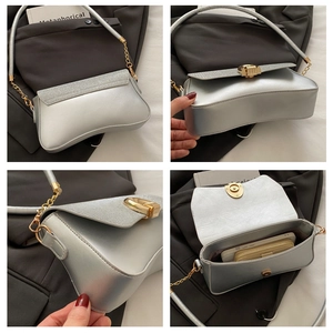 Detail view of silver metallic shoulder bag with glitter trim and gold twist lock closure