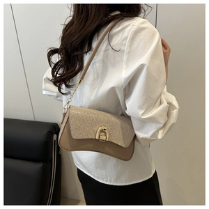 Close-up of khaki sequins flap and golden horseshoe buckle on stylish crossbody bag