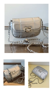 Detailed view of silver quilted chain bag featuring a metallic lock and chain strap