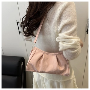 Detail of light pink ruched underarm bag with silky sheen fabric and golden metal buckle