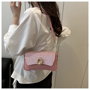 Close-up of pink sequin patchwork bag with a golden horseshoe buckle and leather strap