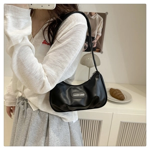 Detail of black crescent moon bag with silver zipper and fashion leather tag