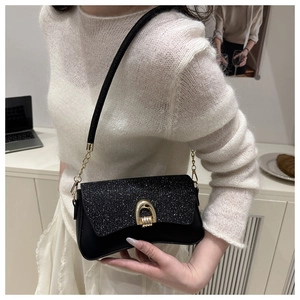 Detail view of shimmering black sequin flap and signature gold horseshoe clasp on the bag