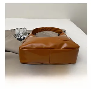 Detailed view of caramel brown bucket bag bottom with reinforced double stitching