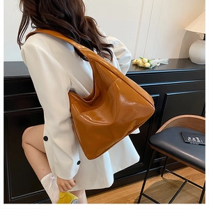 Dettaglio della borsa tote in pelle verniciata marrone caramello con silhouette hobo
