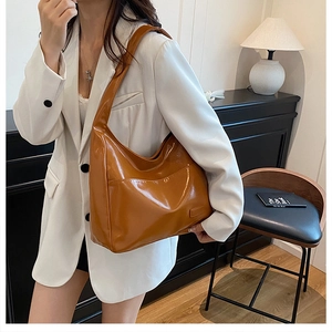 Caramel brown large tote bag in glossy leather worn with a white blazer for work