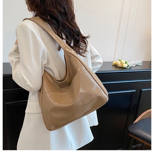 Classic caramel leather hobo bag shoulder view showing large capacity and sleek glossy finish