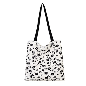 Floral canvas tote bag with black flower print and lace trim detailing on white background