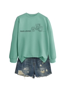 Piatto di una felpa verde menta con stampa trattore e pantaloncini in denim usurati