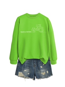Stesura piatta di felpa verde neon con stampa trattore e pantaloncini denim usurati