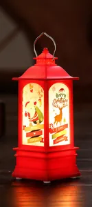Primer plano de farol navideño rojo con luz LED cálida e ilustraciones festivas de Papá Noel
