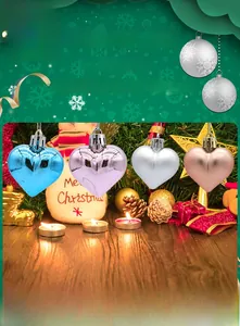 Close-up of heart-shaped Christmas ornaments in blue, pink, and gold on a festive tree