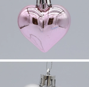 Close-up of pink and silver heart-shaped ornaments with metallic finish and silver caps