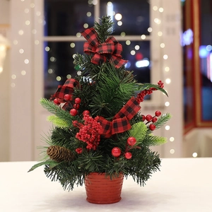 Mini tabletop Christmas tree with red plaid bows, pinecones, and berries on a red base
