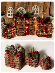 Close-up of three woven Christmas gift boxes with red plaid bows and warm LED lights