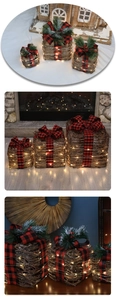 Detail of rattan Christmas gift boxes with LED lights and red black plaid bows