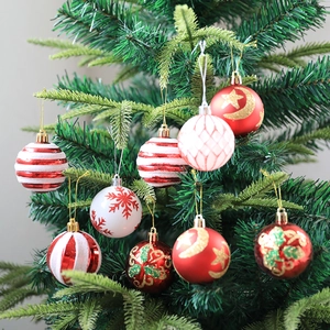 Red and white Christmas ball ornaments with festive patterns hanging on a Christmas tree