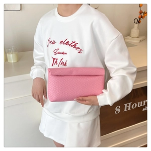 Detailed view of pink woven leather clutch bag with a textured envelope fold-over design