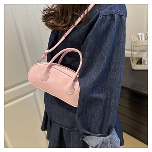 Close-up of pink patent leather Boston bag with silver hardware and smooth texture
