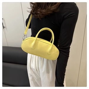 Model wearing a lemon yellow smooth PU leather Boston bag with fine top handles