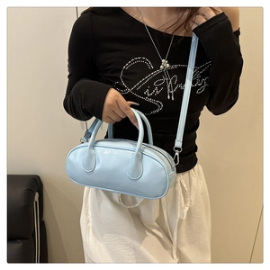 Close-up of a light blue glossy PU leather Boston bag with top handles and shoulder strap