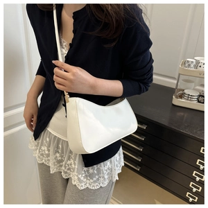 Close-up of a white crescent hobo bag with sleek leather texture and gold hardware
